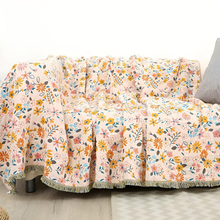 Wendbarer Sofaüberwurf aus Baumwolle mit Gänseblümchen und Quasten