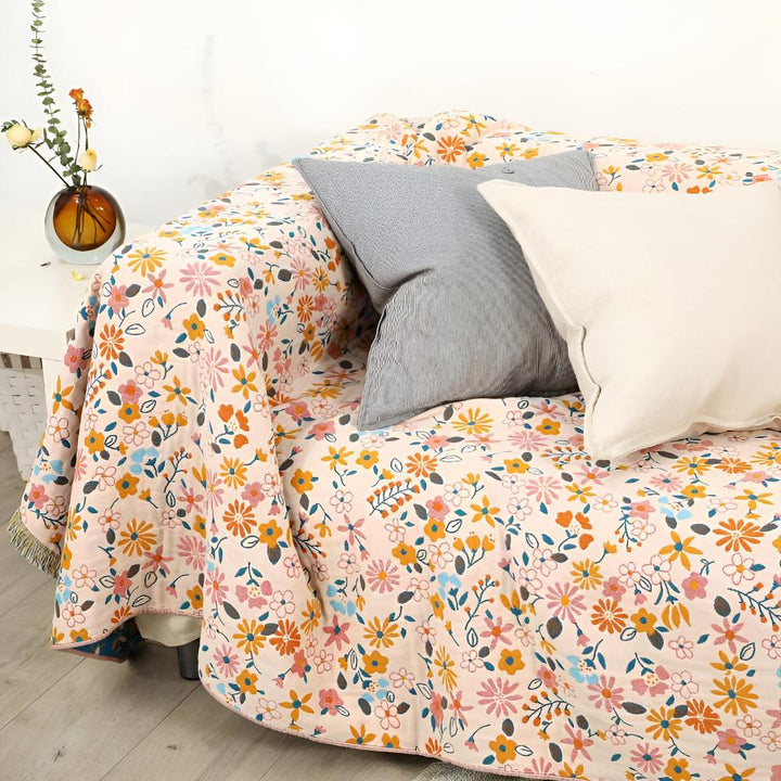 Wendbarer Sofaüberwurf aus Baumwolle mit Gänseblümchen und Quasten