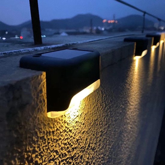 Schwarze Solarleuchten auf einer Dachterrassenmauer in der Dämmerung