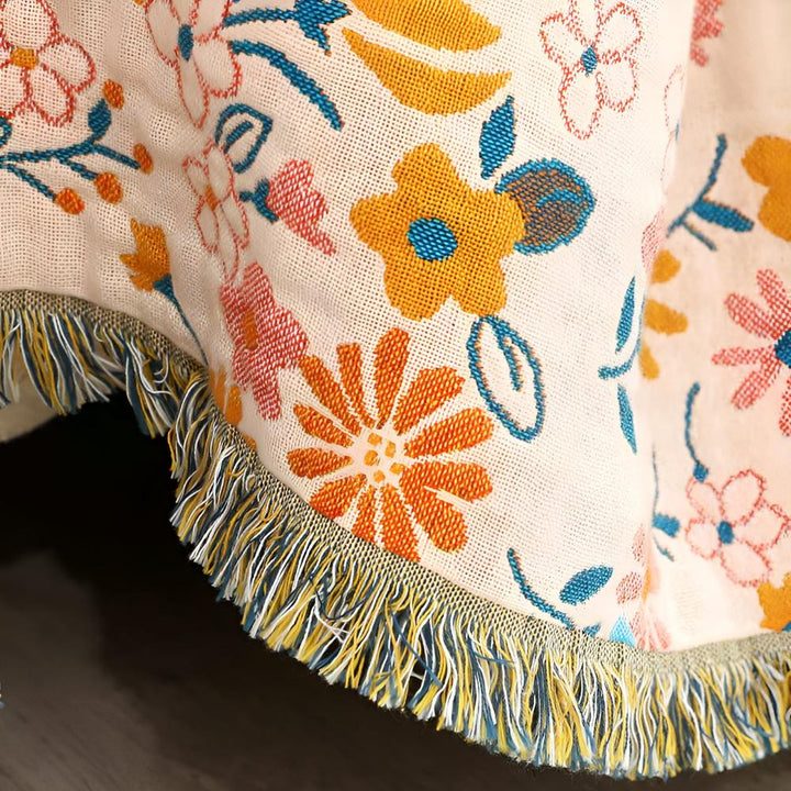 Wendbarer Sofaüberwurf aus Baumwolle mit Gänseblümchen und Quasten