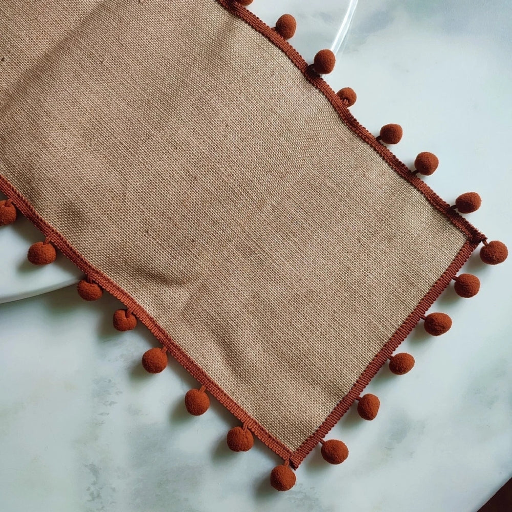 Jute-Tischläufer mit orangefarbenen Pompons