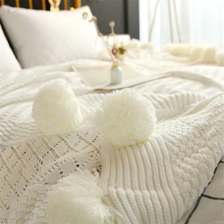 Gestrickte Decke mit Pompons