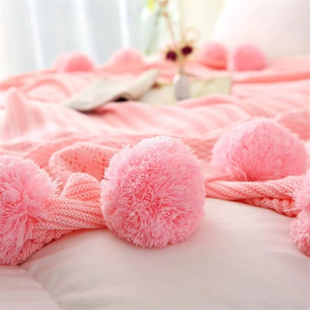 Gestrickte Decke mit Pompons