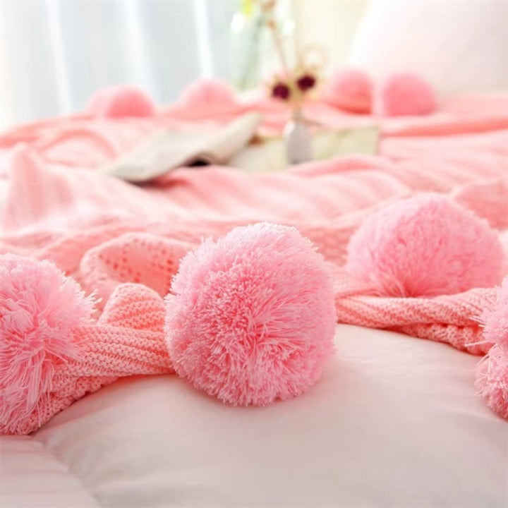 Gestrickte Decke mit Pompons