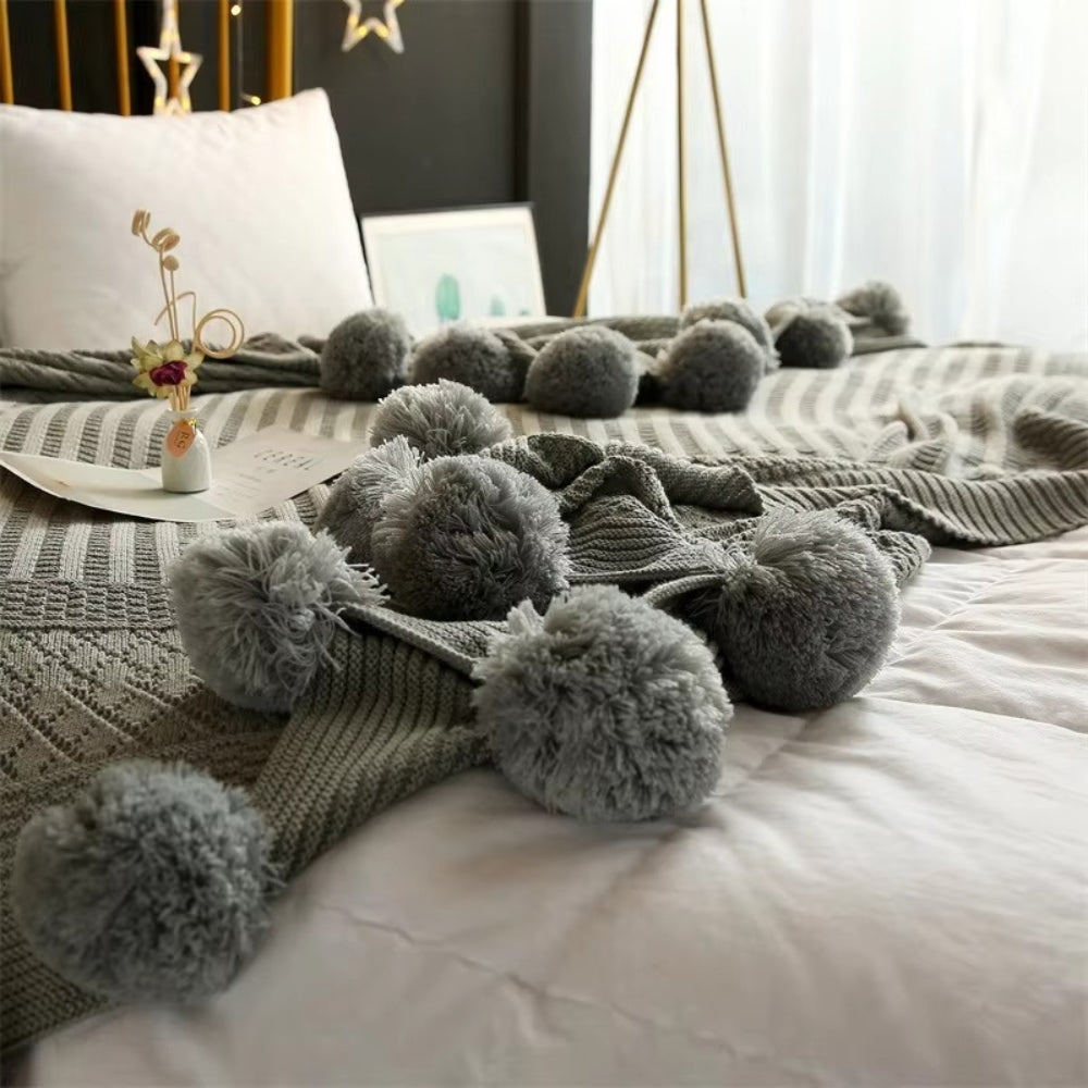 Gestrickte Decke mit Pompons