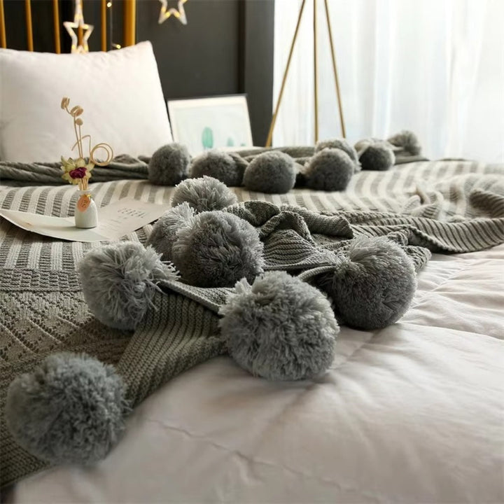 Gestrickte Decke mit Pompons