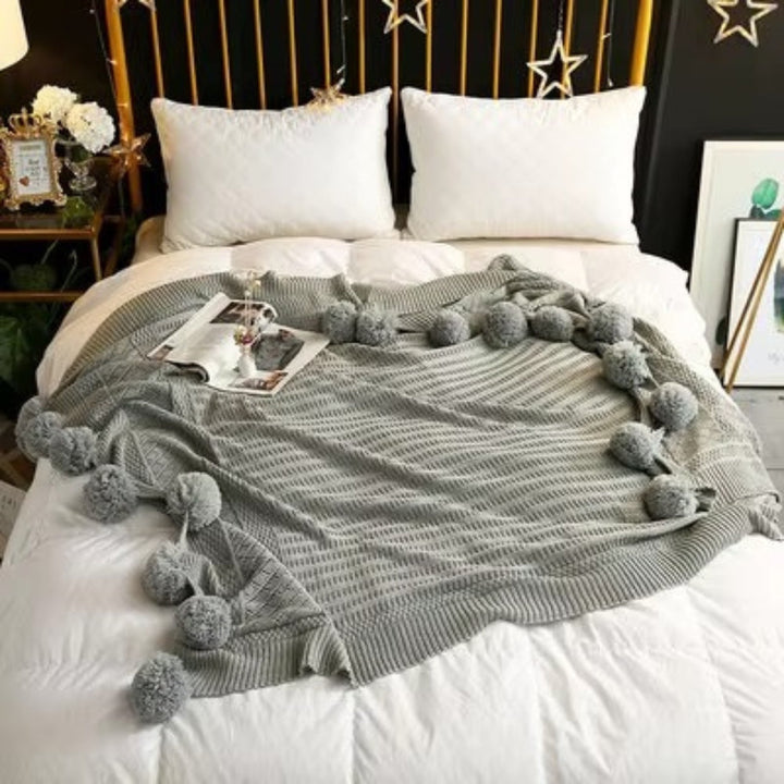 Gestrickte Decke mit Pompons