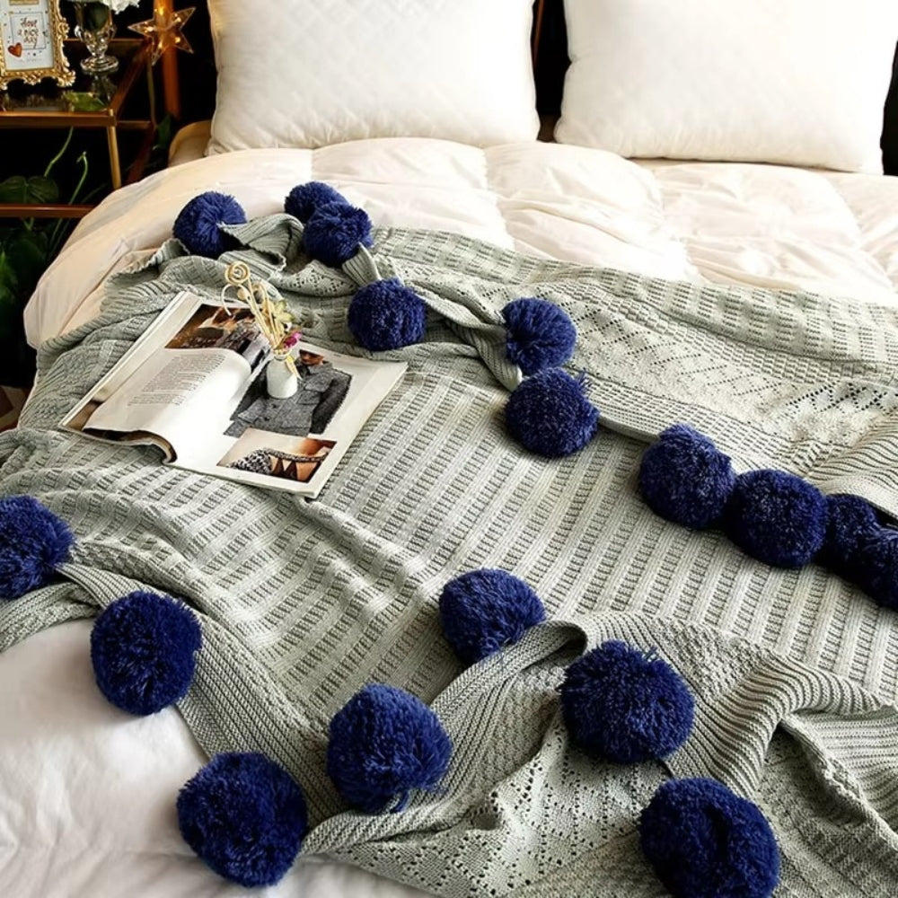 Gestrickte Decke mit Pompons