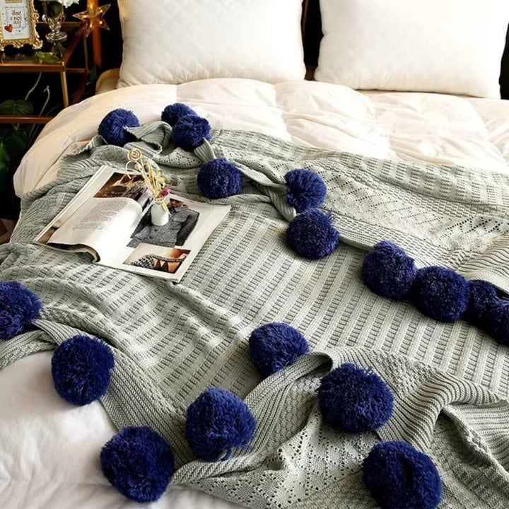 Gestrickte Decke mit Pompons