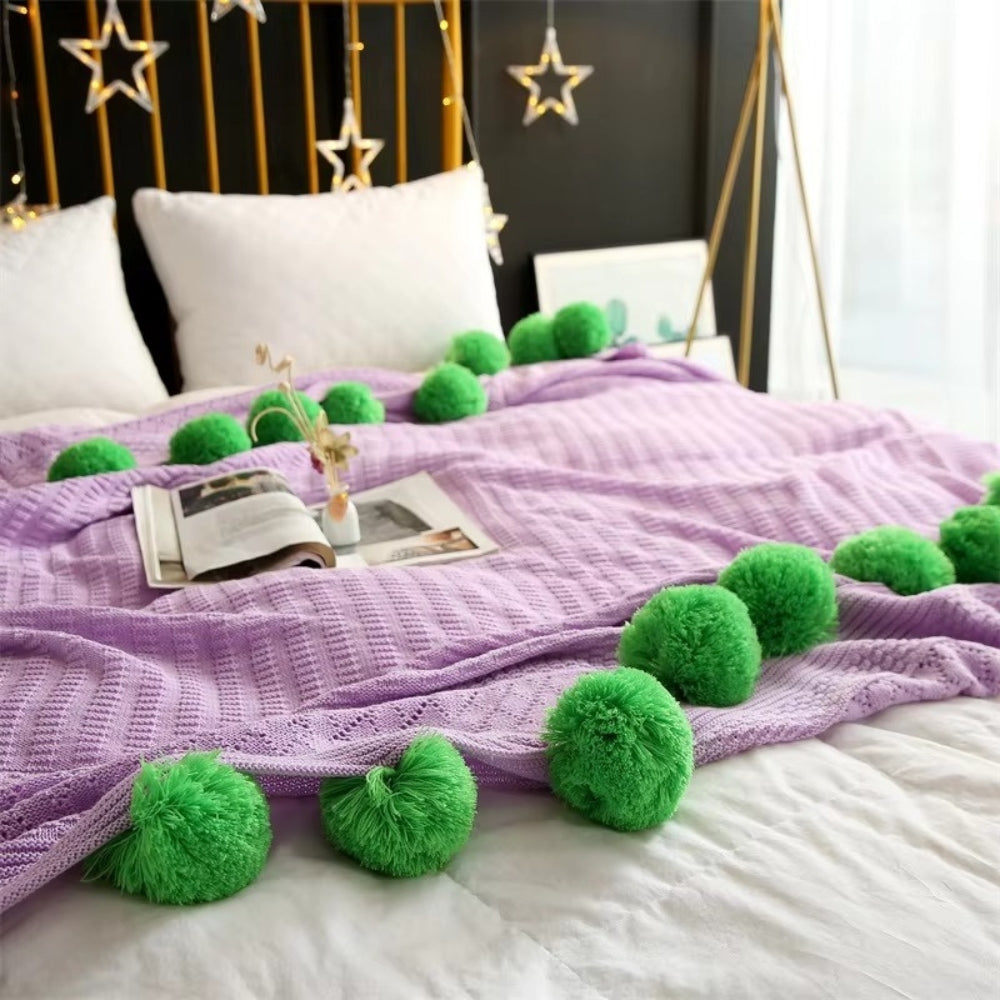 Gestrickte Decke mit Pompons