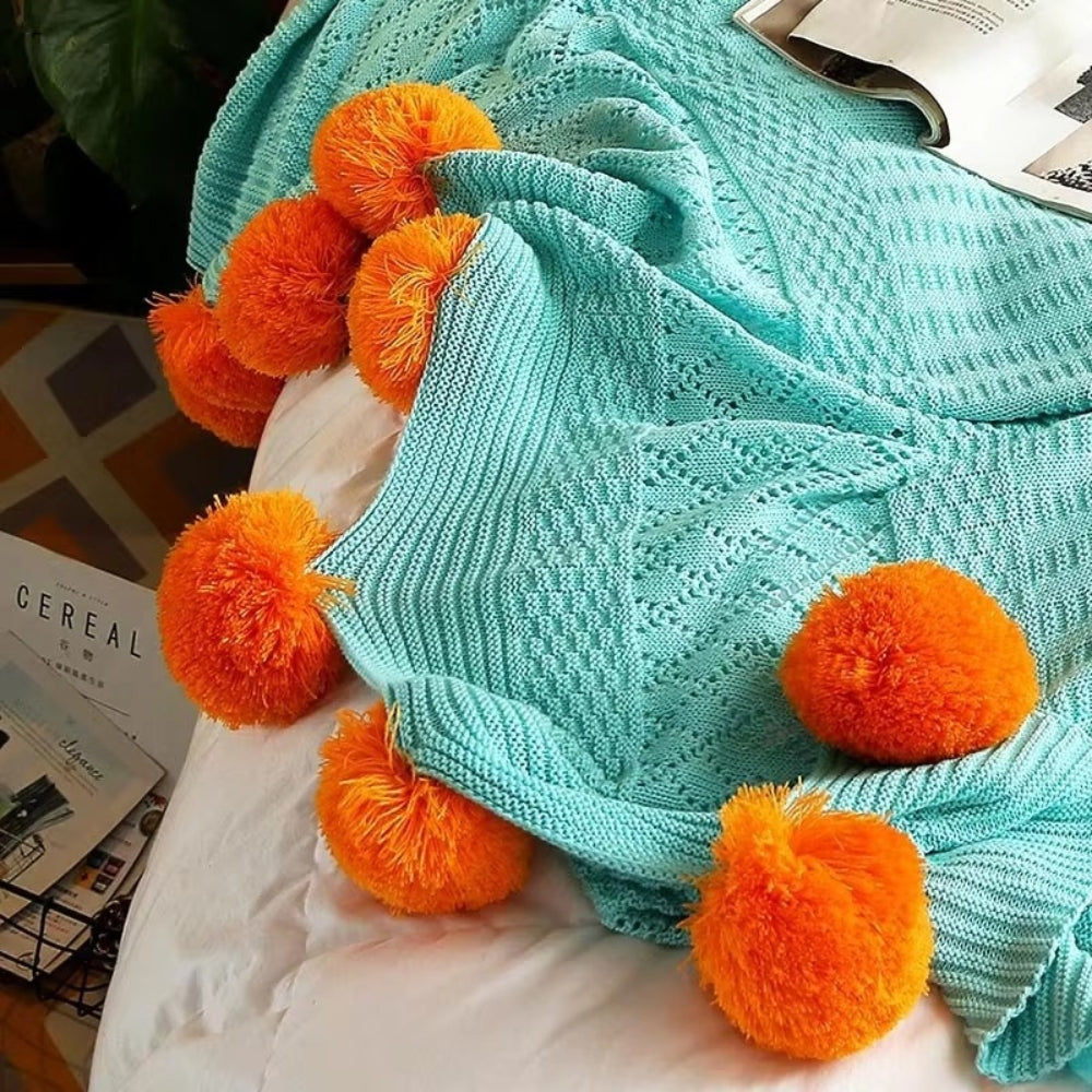 Gestrickte Decke mit Pompons