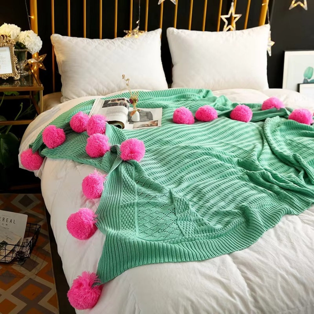 Gestrickte Decke mit Pompons