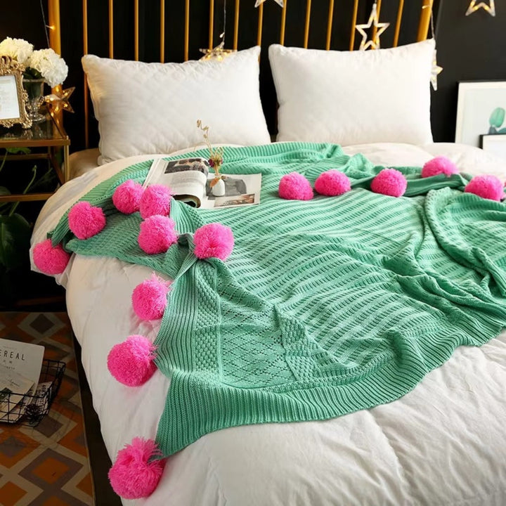 Gestrickte Decke mit Pompons