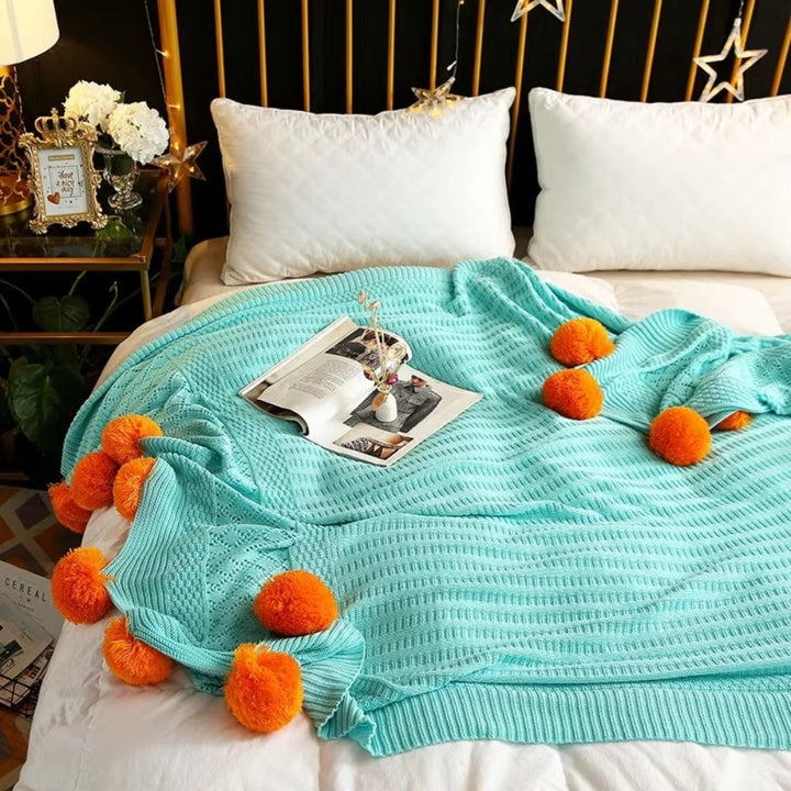 Gestrickte Decke mit Pompons