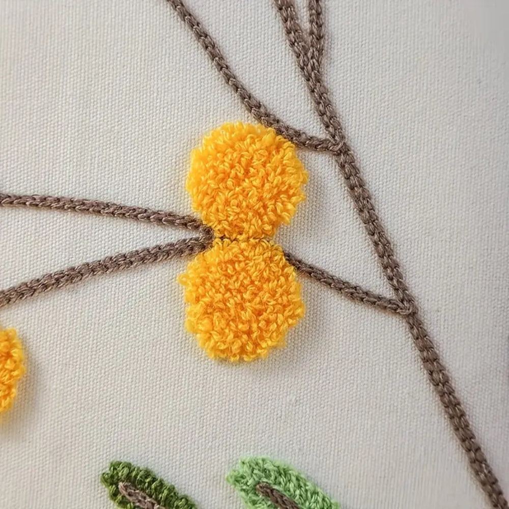 Kissenhülle mit gelben Blumenstickereien auf festem Stoff